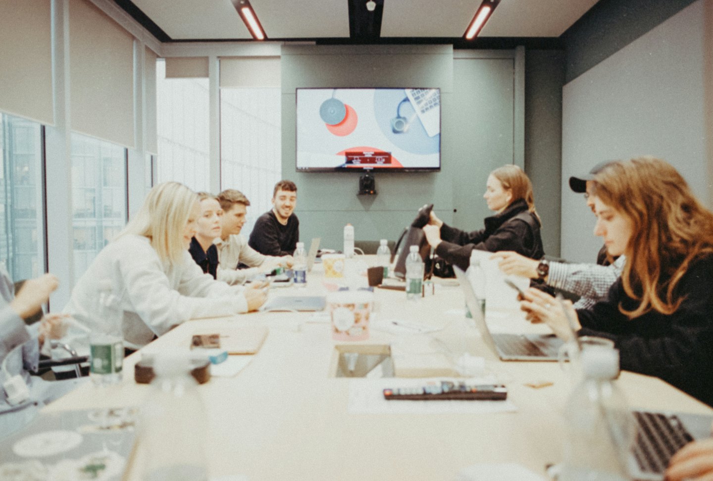 Profis arbeiten mit Laptops an einem Konferenztisch zusammen.
