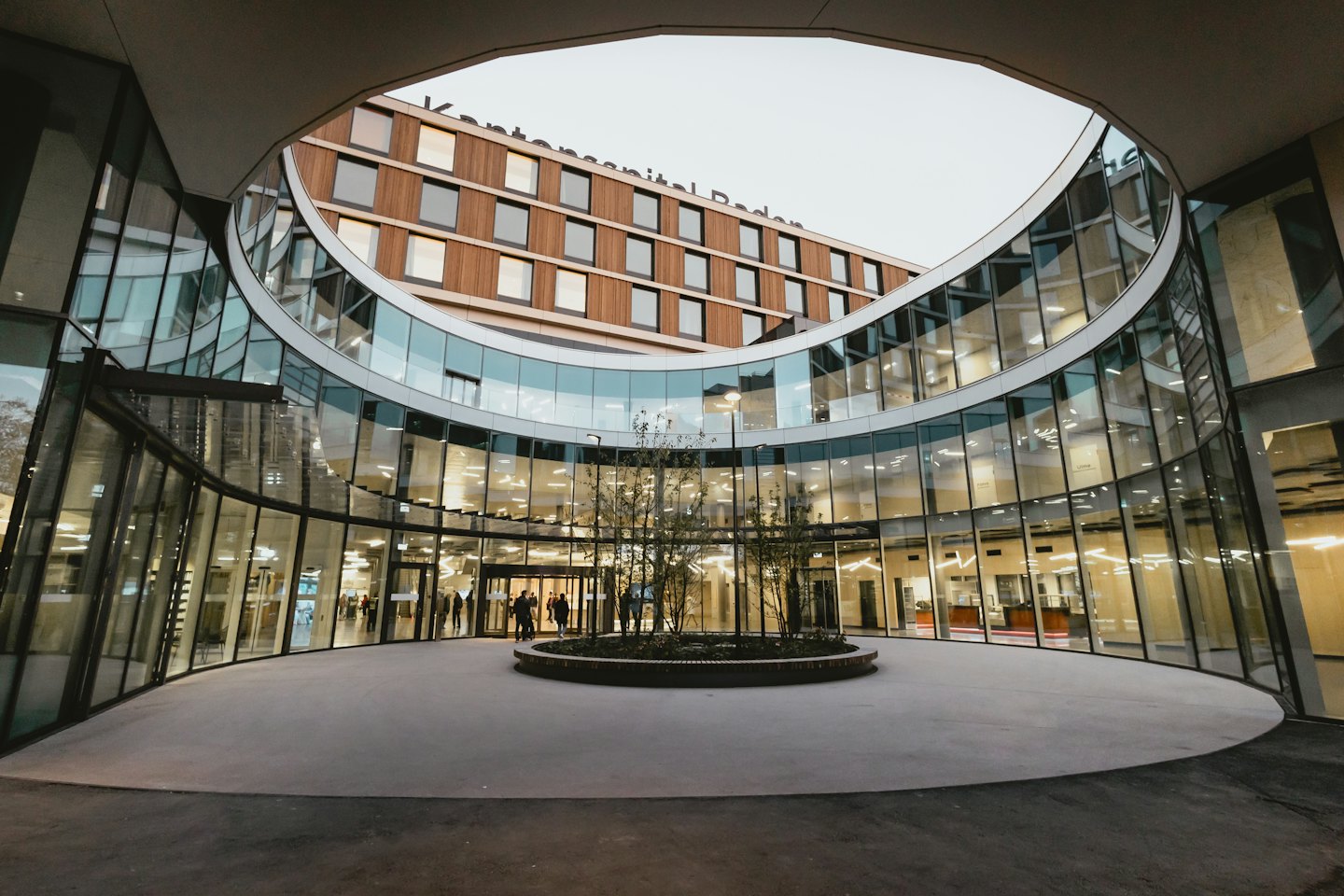 Modernes Krankenhausgebäude mit Glasfassade und Innenhof.
